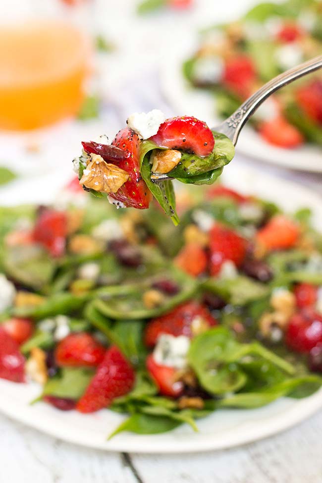 This Strawberry Walnut Salad features spinach, blue cheese, cranberries, and is topped with a fantastic poppy seed dressing. Perfect for summer! | yummyaddiction.com