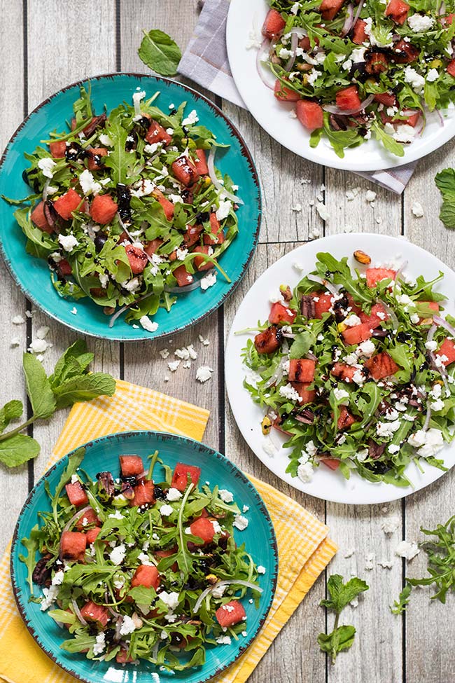 This Arugula Watermelon salad also features feta cheese, mint, pistachios, and olives! Perfect for summer! | yummyaddiction.com