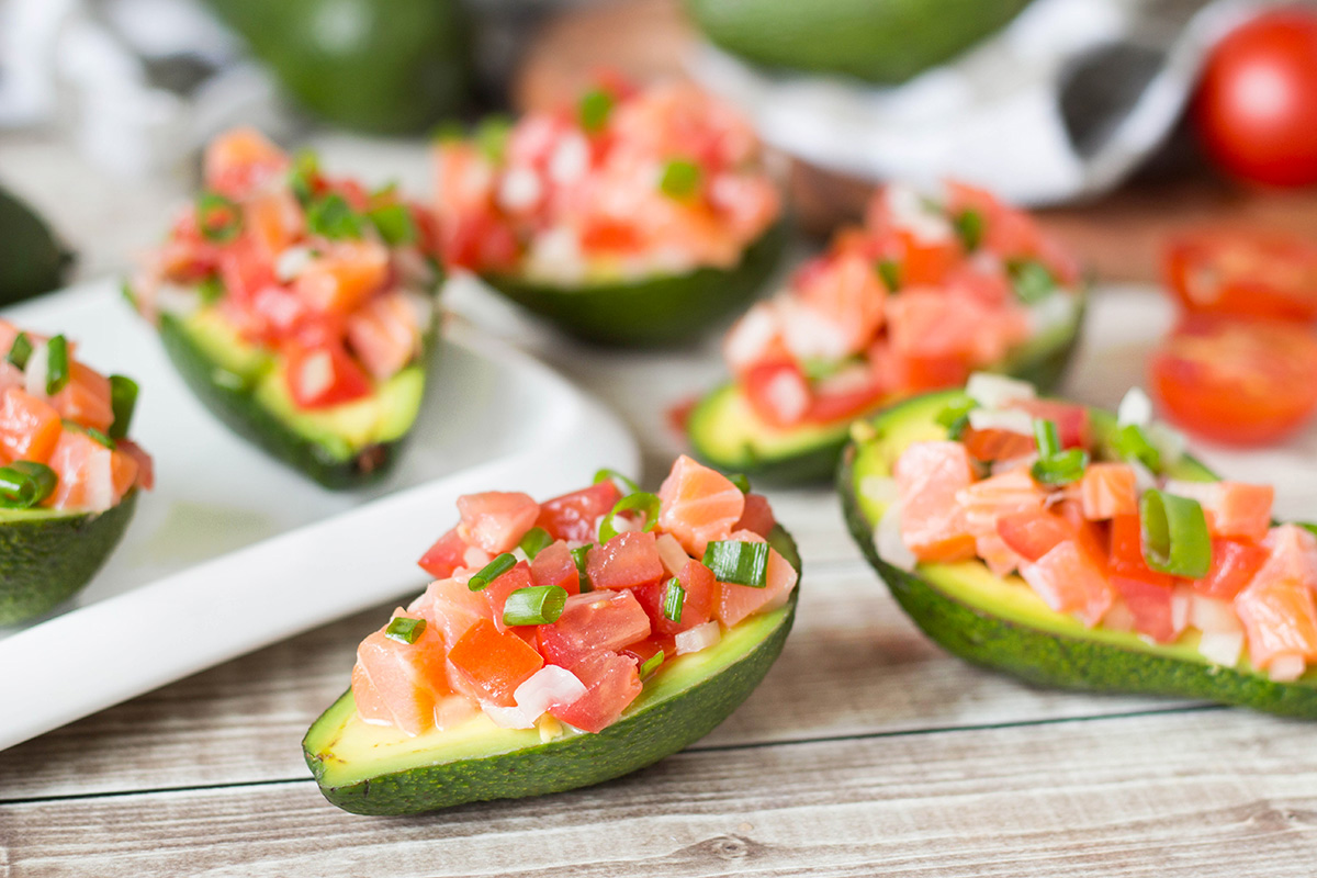 Lomi Lomi Salmon is a famous Hawaiian dish served alongside roasted meats or eaten as a standalone salad. I decided to make an appetizer out of it and served this goodness in avocado halves! | yummyaddiction.com
