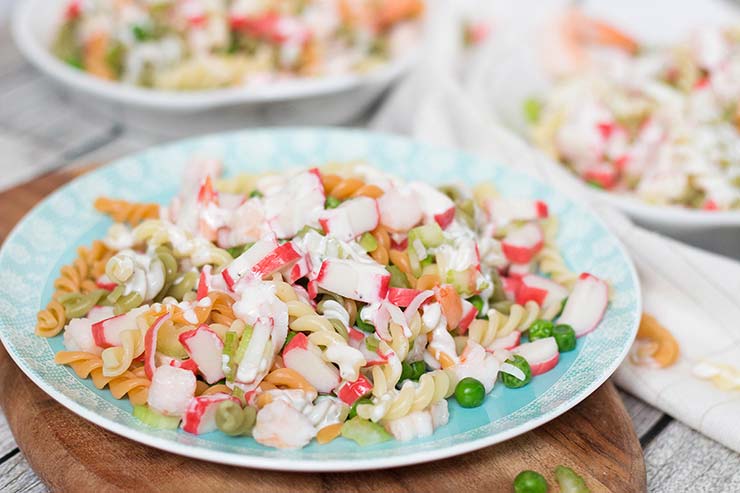 This Seafood Pasta Salad is comforting, hearty, and filling. It features pasta, imitation crabmeat, shrimp, and veggies together with a mayo or yogurt dressing! | yummyaddiction.com
