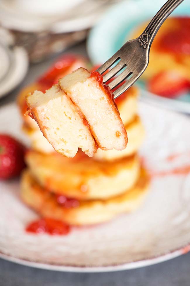 These famous Russian sweet cheese pancakes (Syrniki) are made with cottage cheese and served with a gorgeous fresh strawberry sauce. SO GOOD! | yummyaddiction.com
