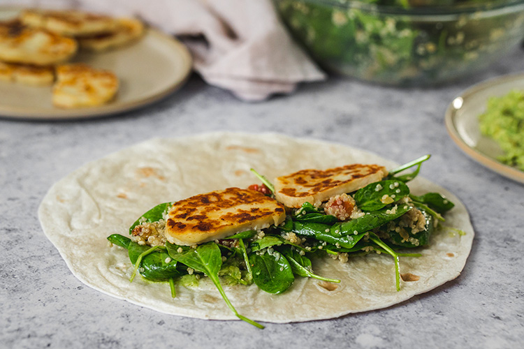 Quinoa covered spinach and fried halloumi slices in the middle of tortilla