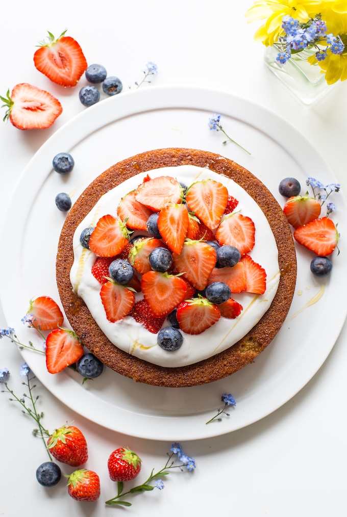Coconut flour cake topped with fresh strawberries and blueberries 