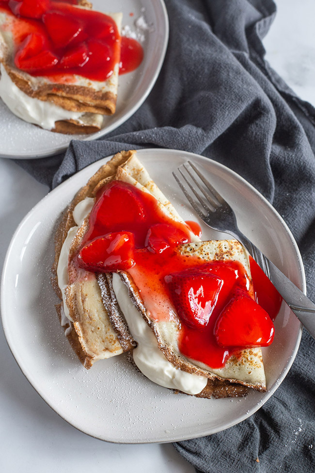 Cream cheese filled crepes with strawberries on top