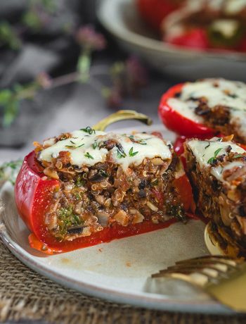 A mushroom and quinoa stuffed pepper cut open down the middle to show the filling