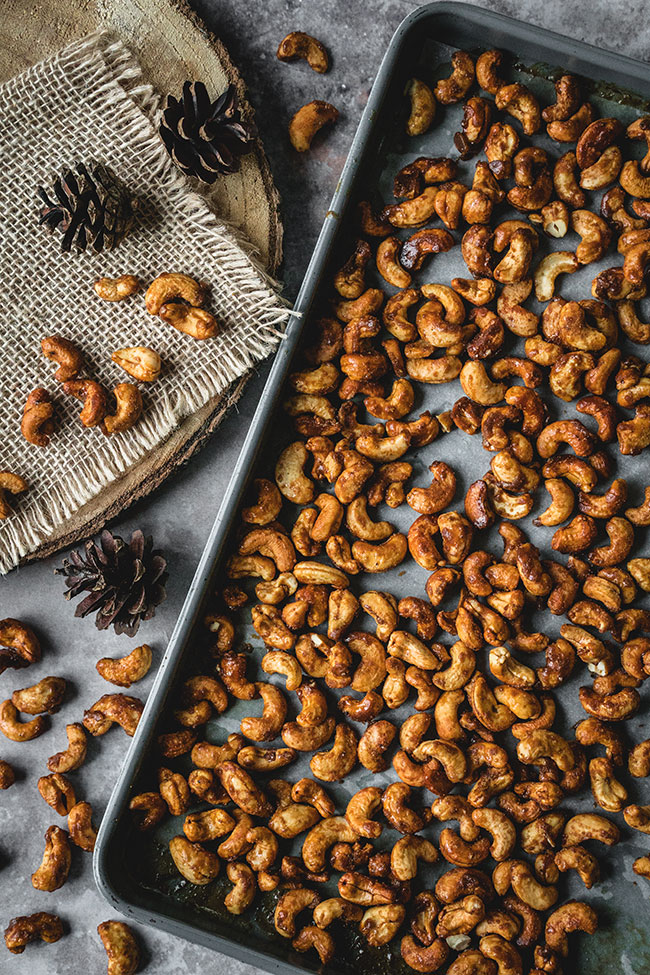 Honey roasted cashews with holiday spices on a baking sheet