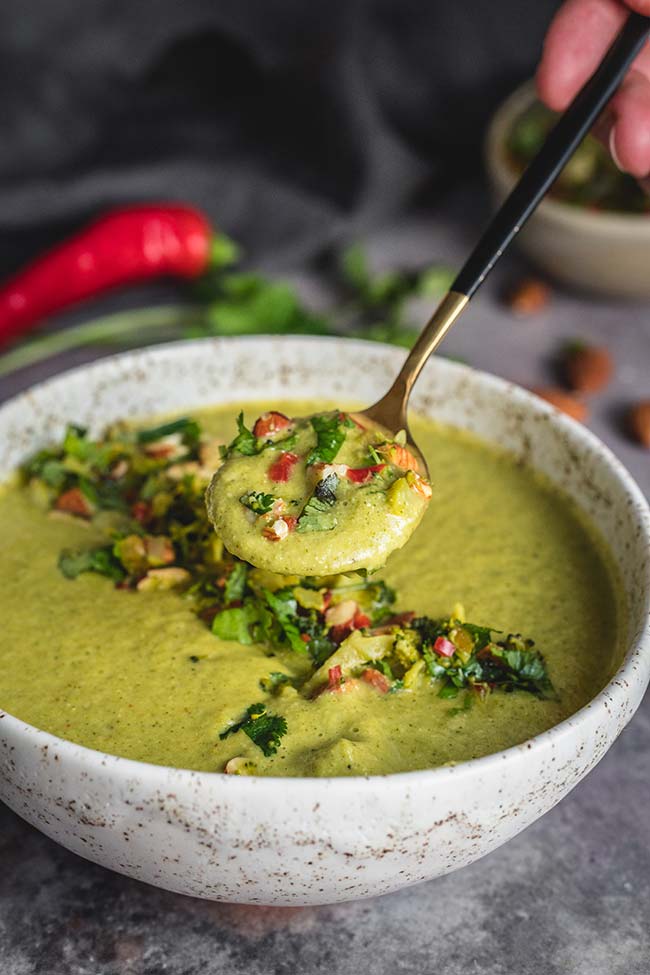 A spoonful of broccoli soup with almonds
