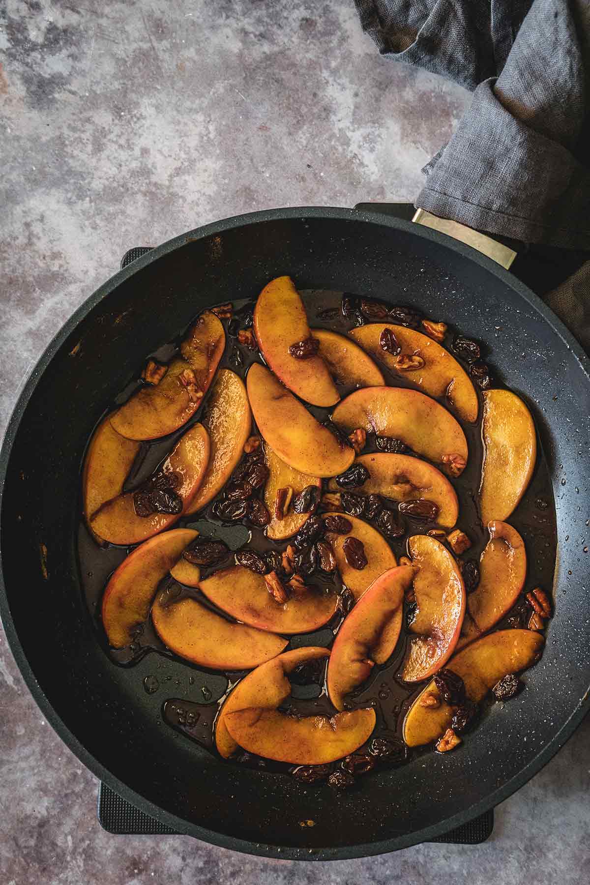 Caramelized cinnamon apples with raisins in the skillet