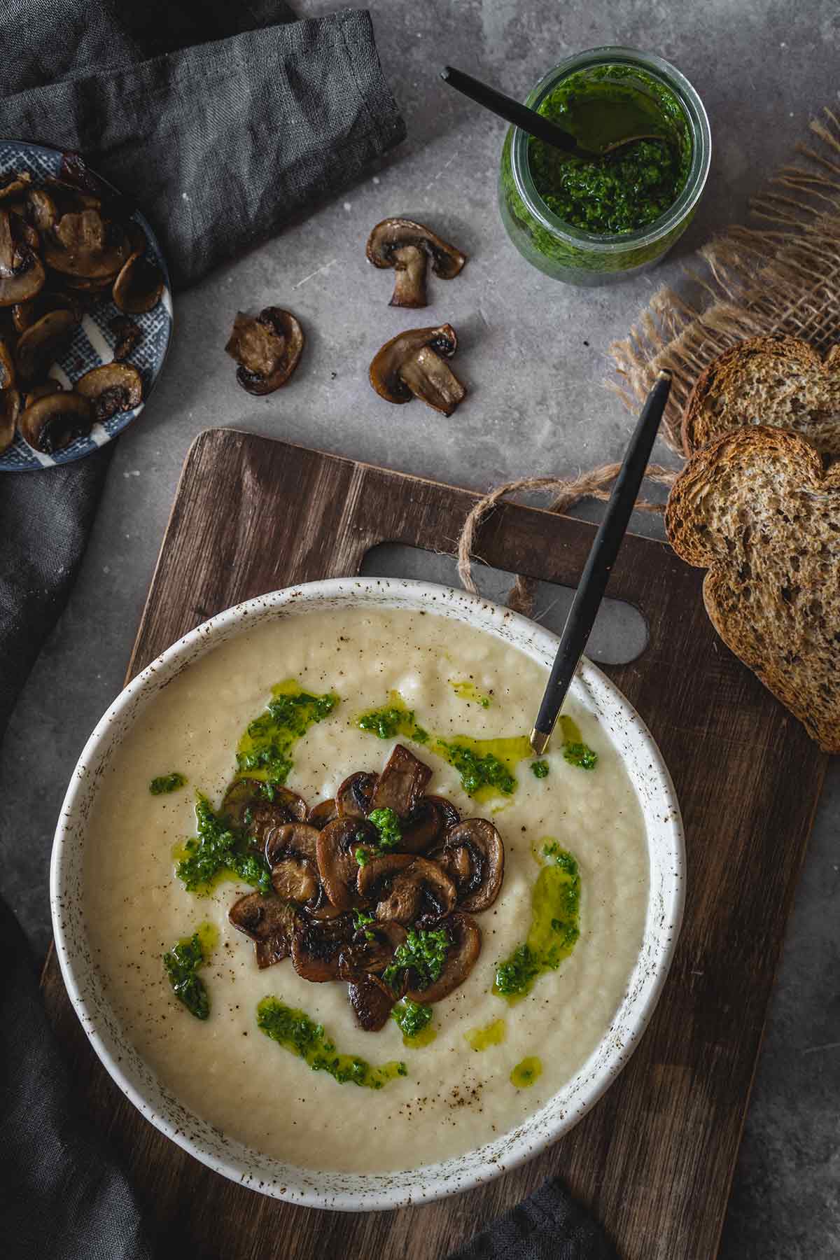 Celery root soup served in a bowl and topped with mushrooms