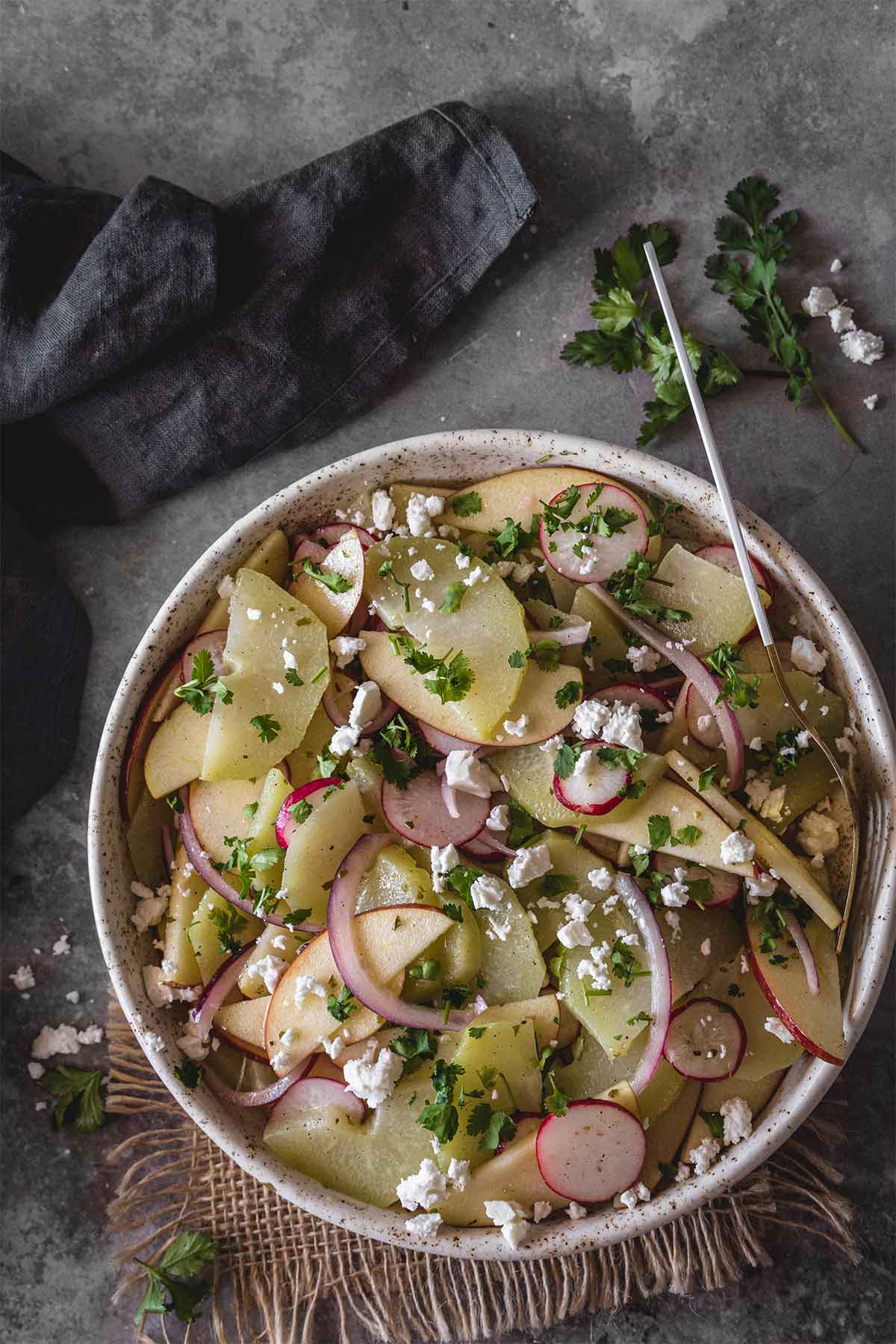 Chayote salad with apple and radishes in a bowl