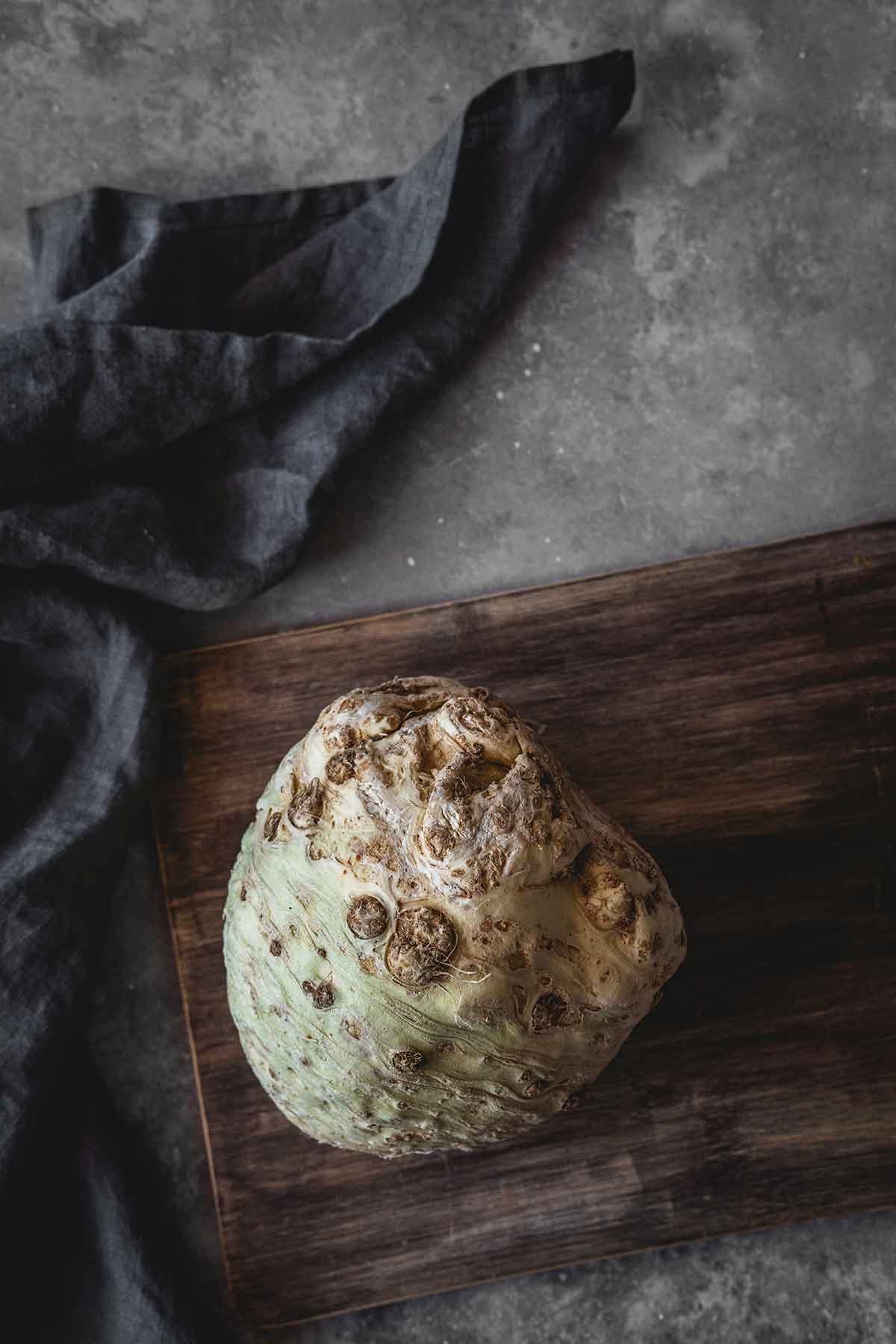 Whole celery root on a wooden cutting board