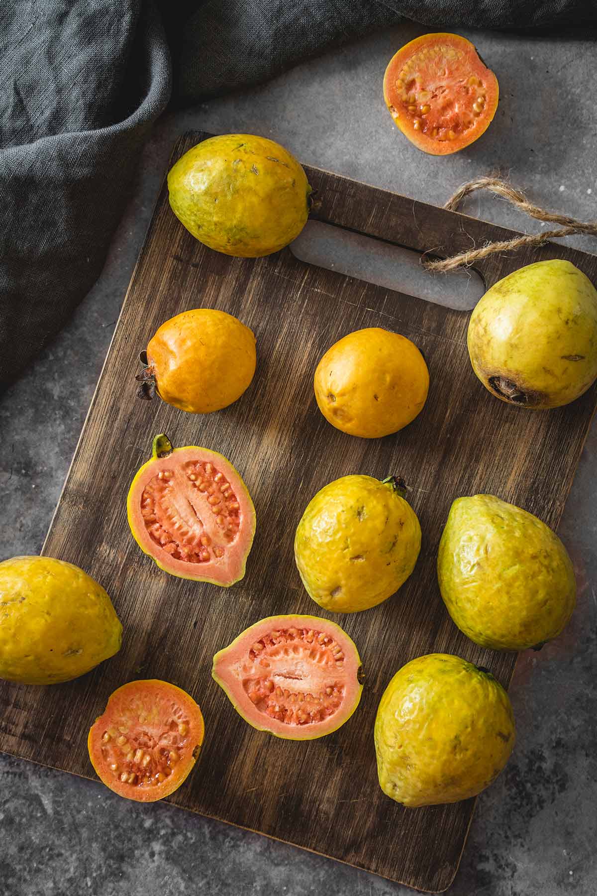 Different types of guava on a wooden cutting board overhead shot