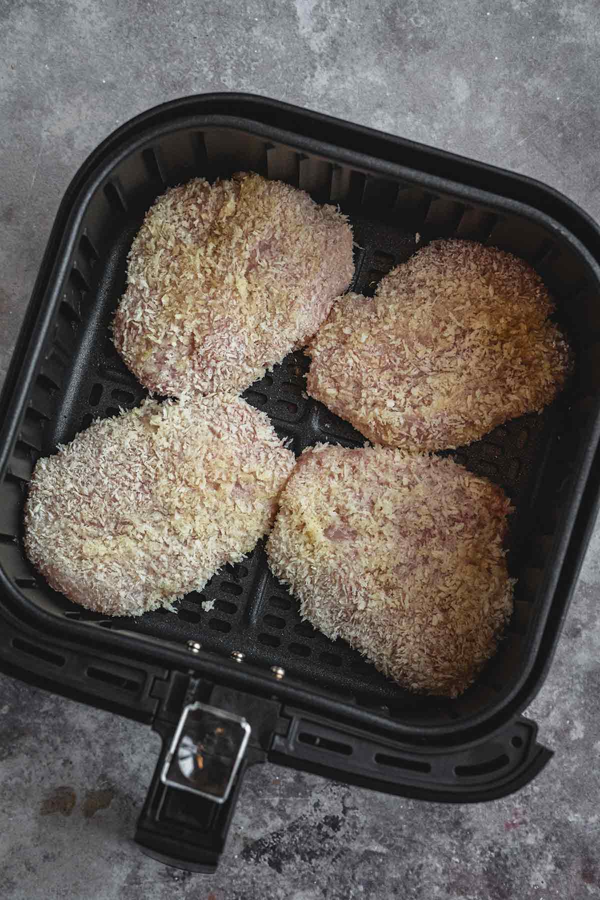 Raw breaded chicken cutlets in air fryer