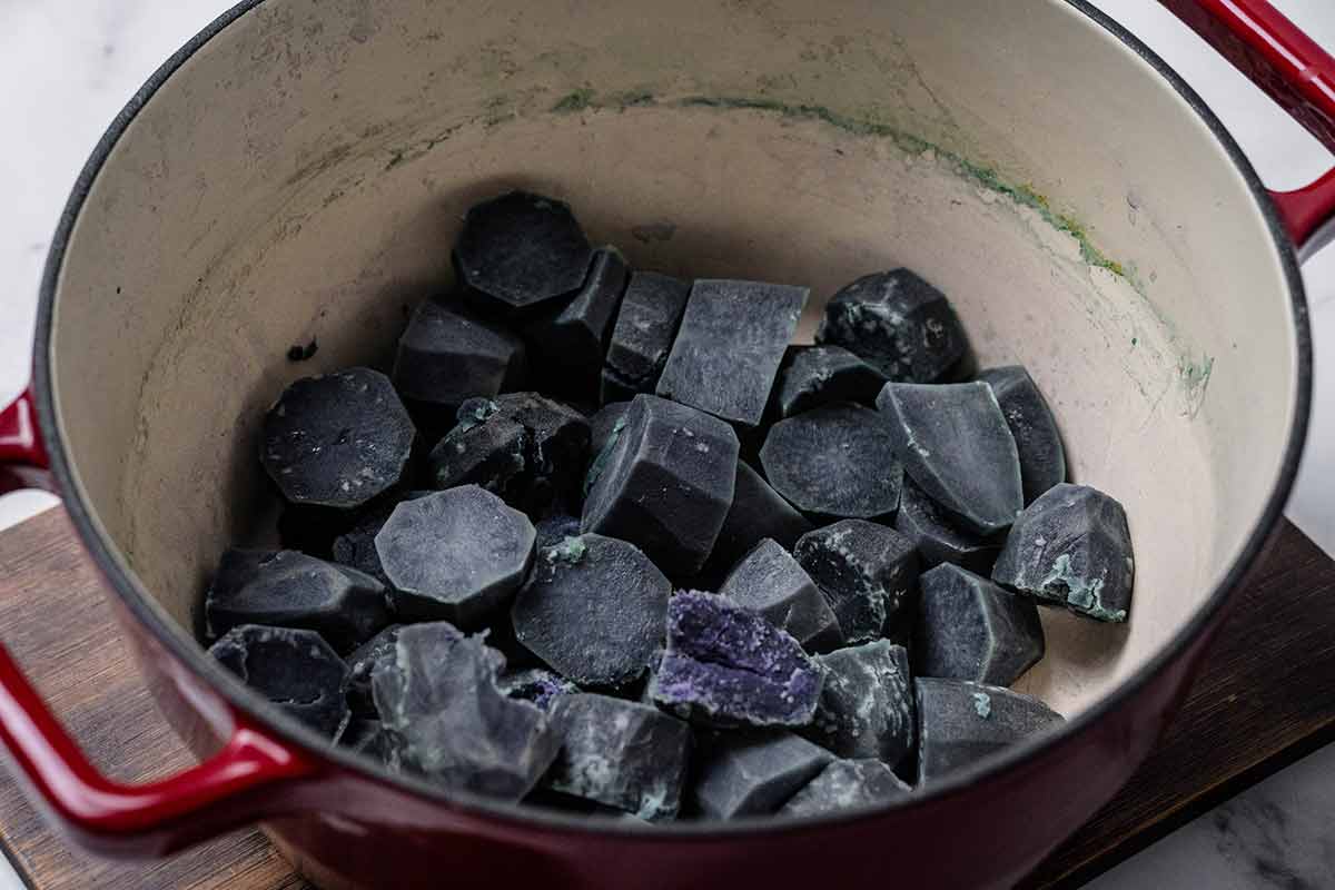 Cooked purple potatoes in a pot