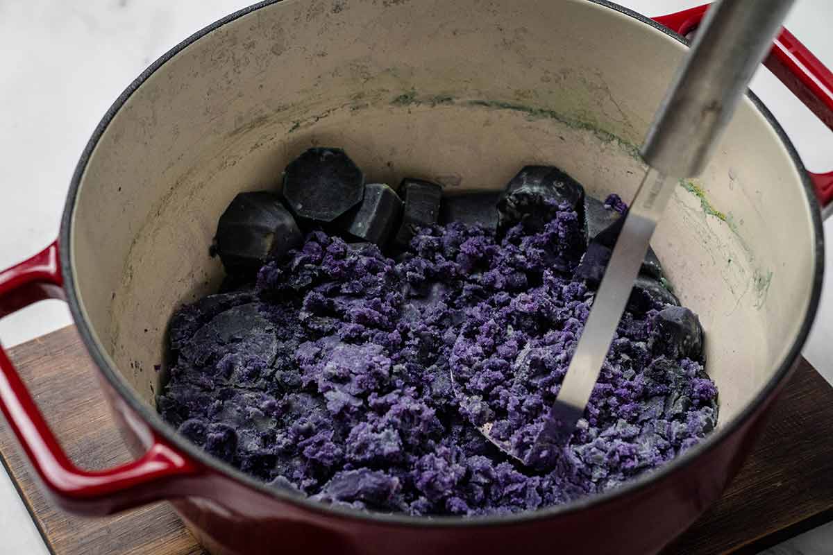 Mashing cooked purple potatoes
