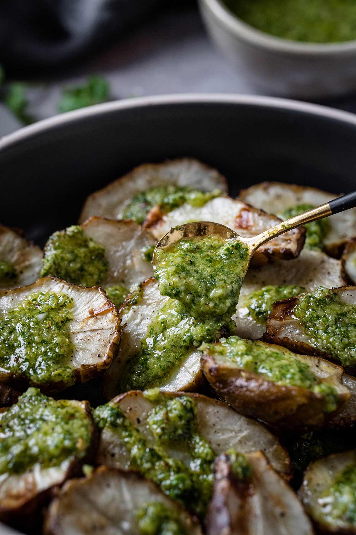 Pouring chimichurri over the sunchokes