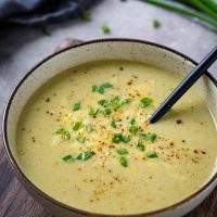 Green onion soup garnished with cheese featured photo