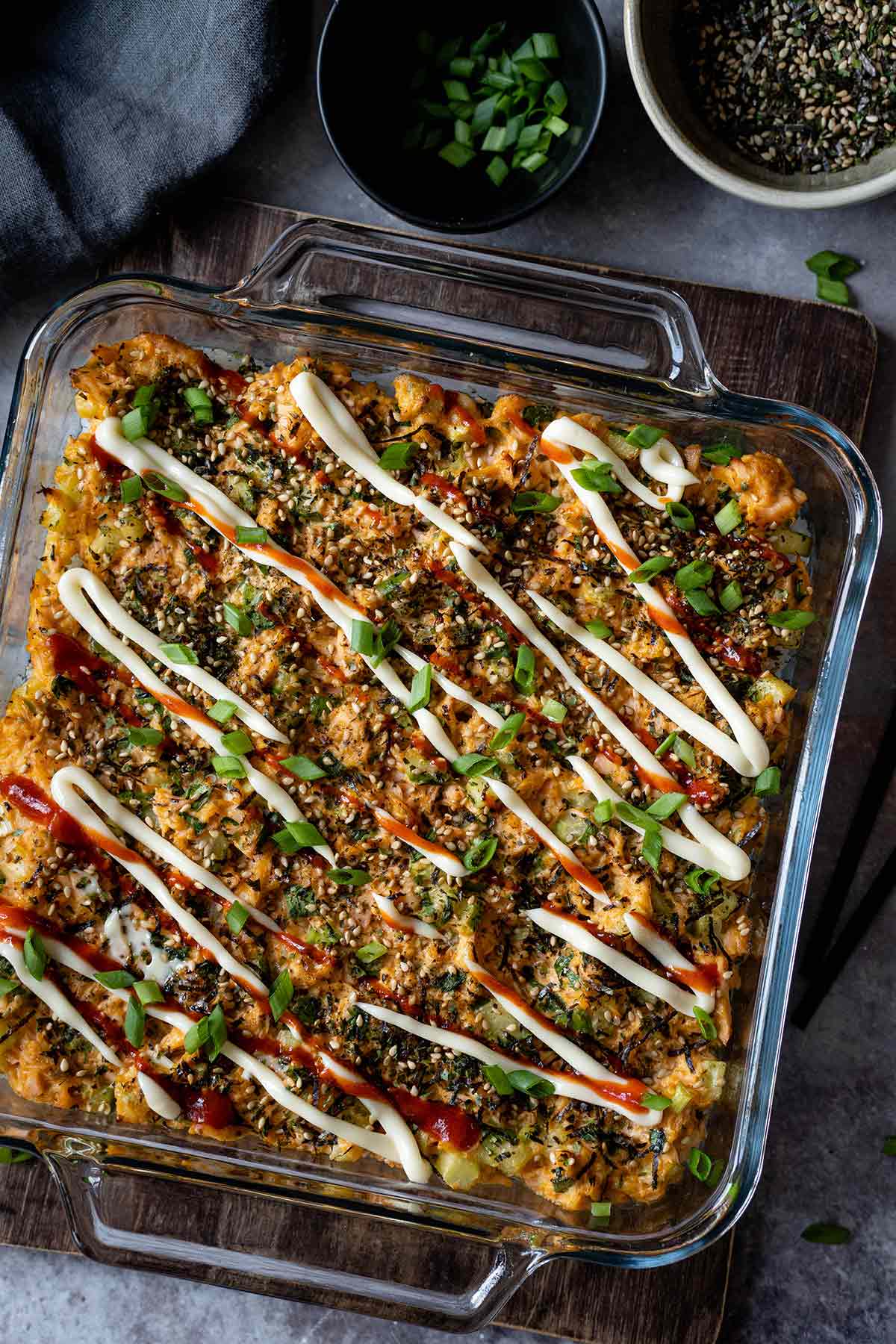 Salmon sushi casserole topped with kewpie mayo and sriracha